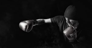 A boxer wearing gloves punching on the air