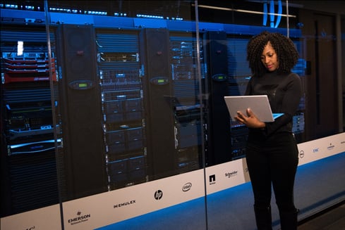 A woman standing next to a data center